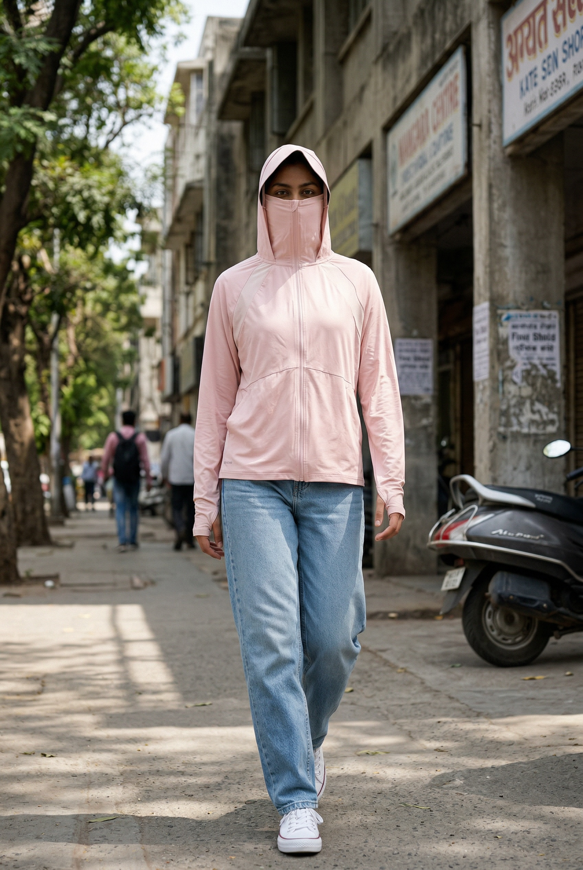 Rider walking in a pink VEYIL UV jacket with hood and face cover
