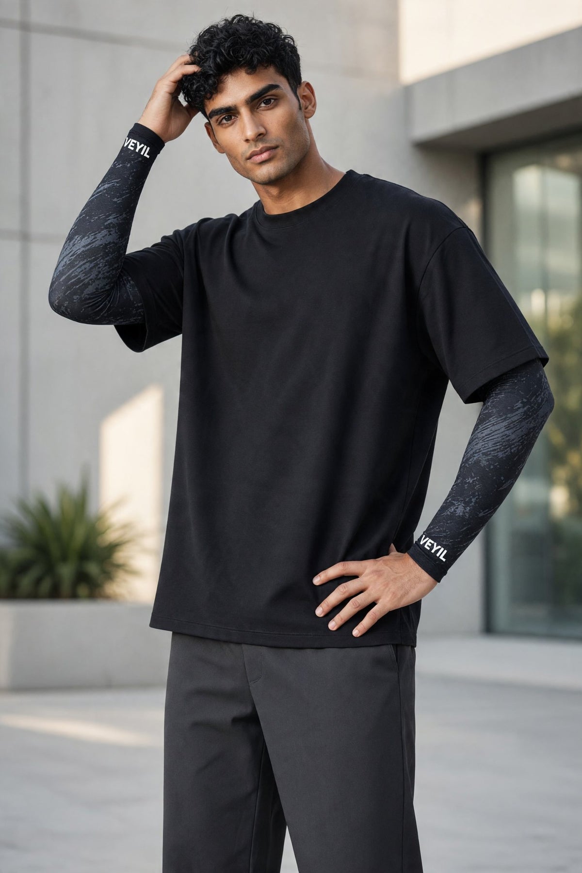 Man wearing black VEYIL UPF 50+ cooling arm sleeves under a black T-shirt